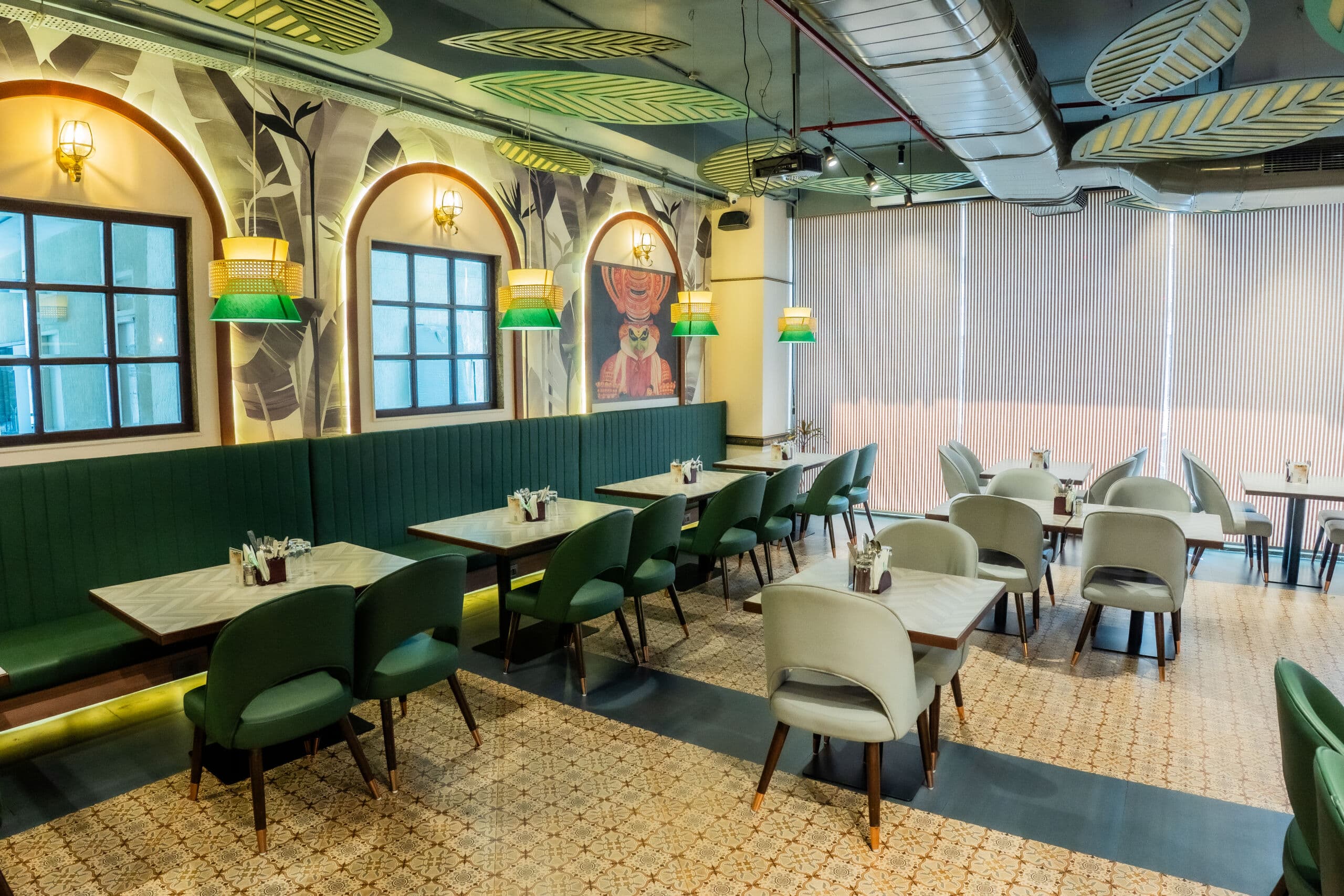 Kerala Table dining hall — green booth seating with warm ambient lighting